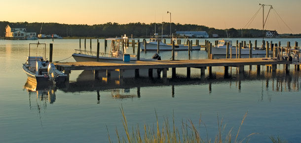 boats along dock on water at sunset