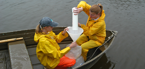 graduate students taking samples in small boat